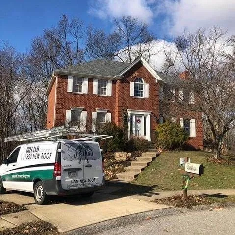Two-story brick colonial home with a completed roof replacement by Ireland Contracting