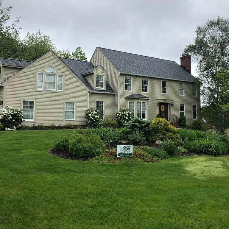 Two-story home with light siding and a new architectural shingle roof