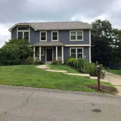 Gray two-story home with a freshly paved driveway and new roof