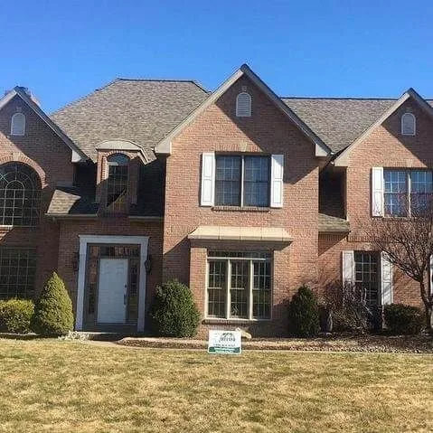 Tan brick home with arched windows and a completed exterior renovation