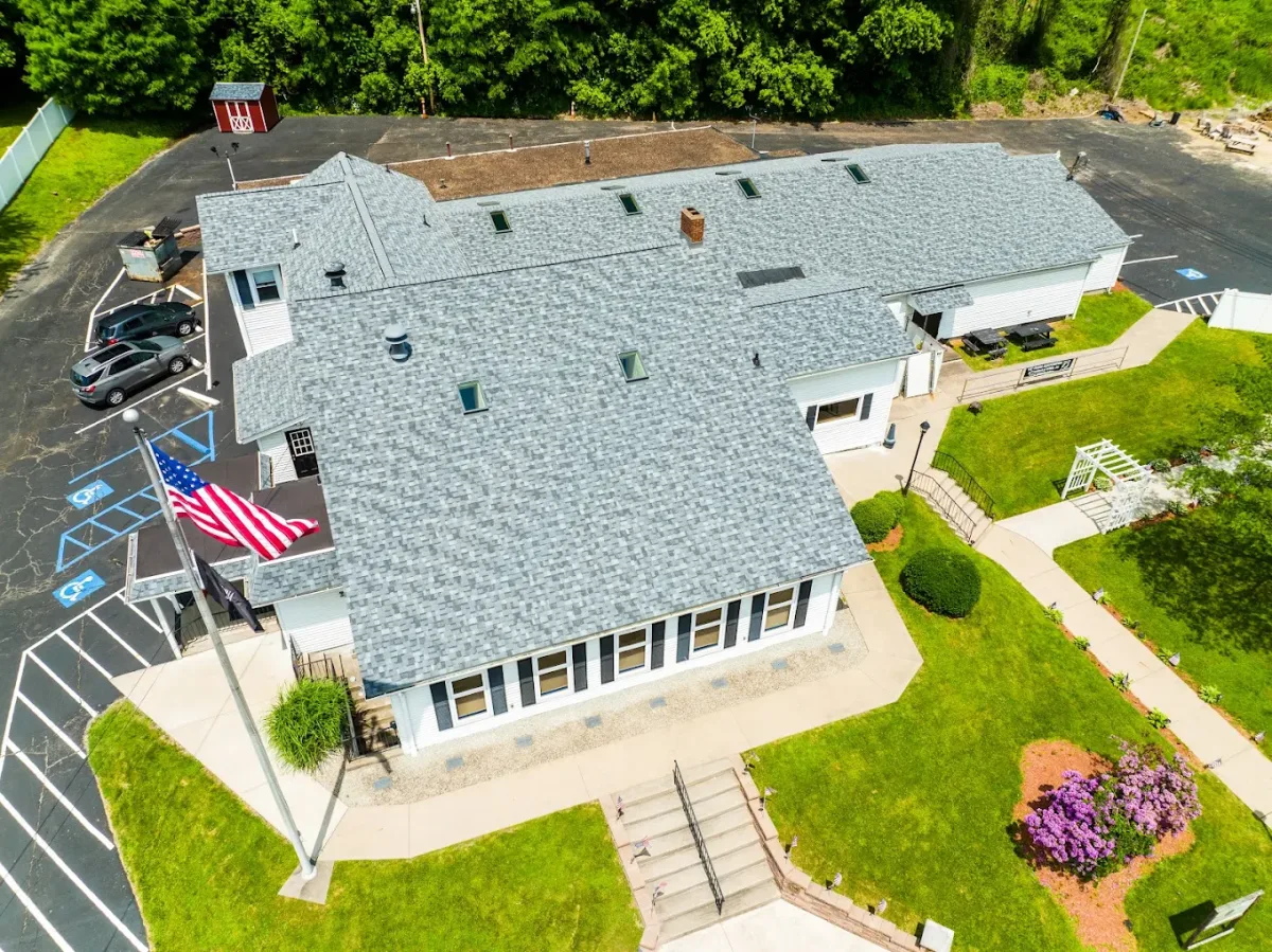 Aerial drone view of a completed shingle roof flying an American flag