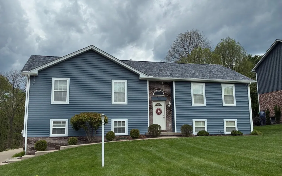 Split-level home with freshly installed blue-gray lap siding and white trim